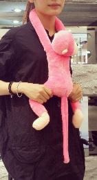 Peluche rose réaliste d'un singe amoureux de câlins