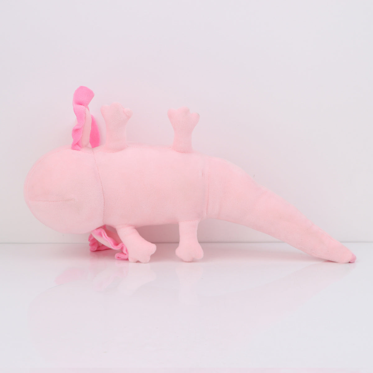 Peluche axolotl rose, compagnon allongé plutôt qu'assis