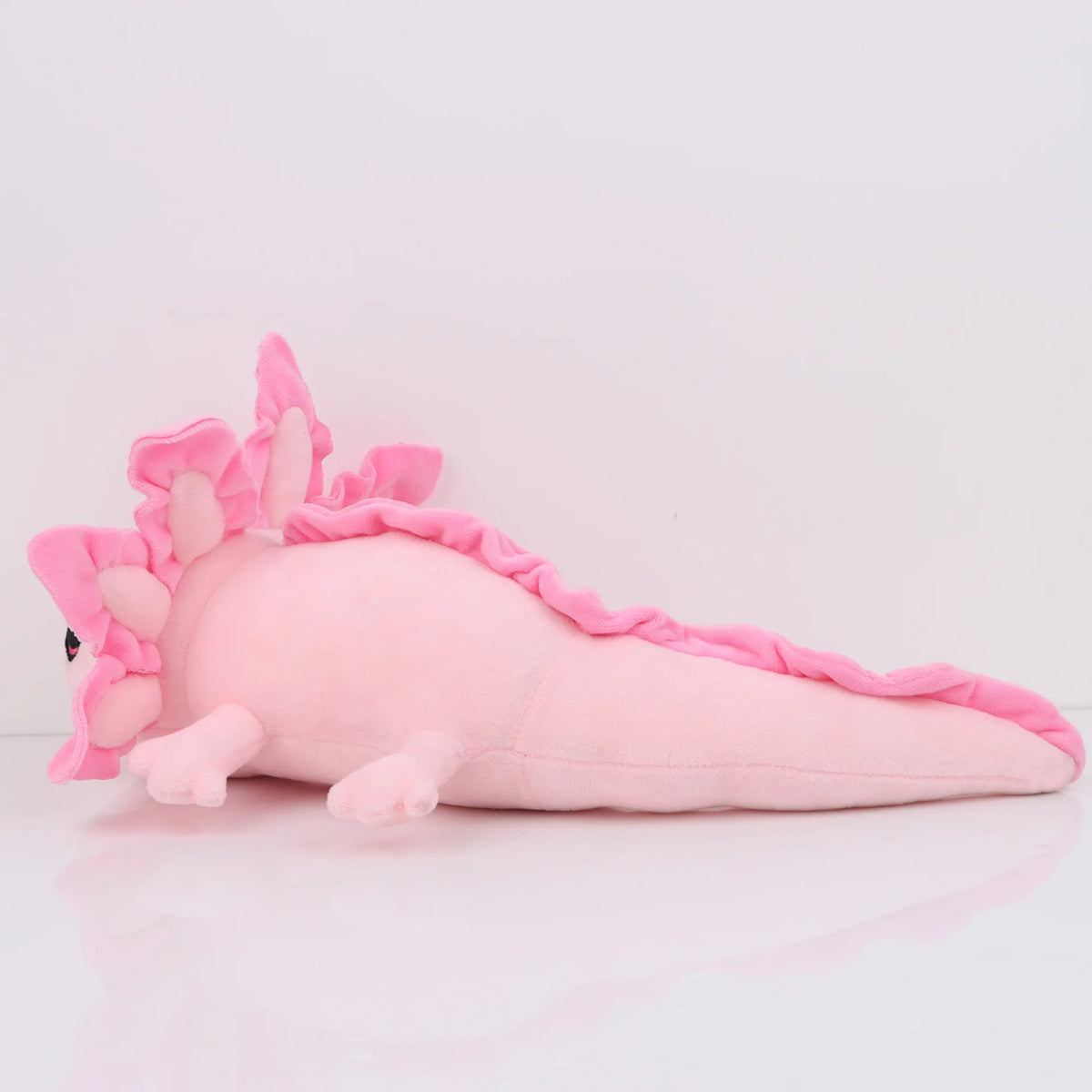 Peluche axolotl rose, longue queue plate et corps bas sur ses pattes