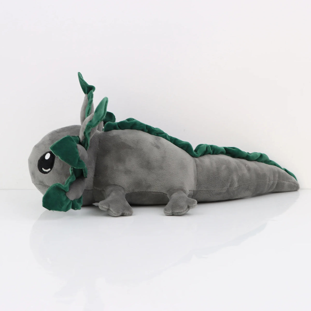 Peluche axolotl grise, assise stable sans aucun support