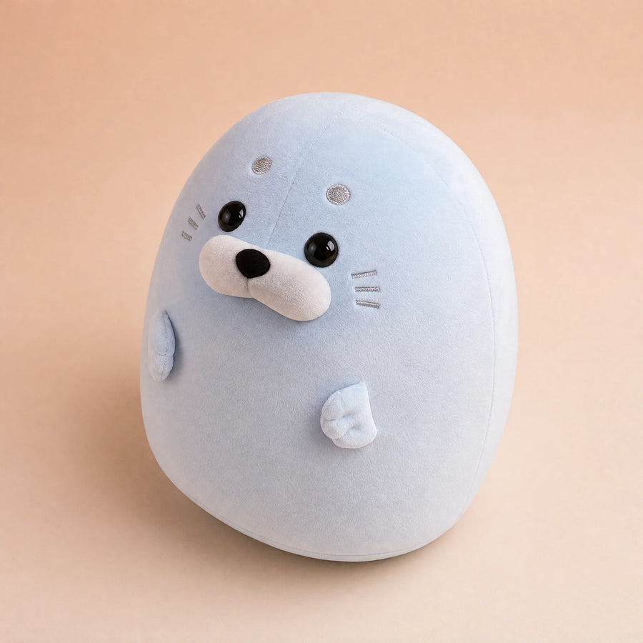 Peluche Phoque Rebondie Blanc ou Bleu Pastel - Fond beige rosé, autre angle